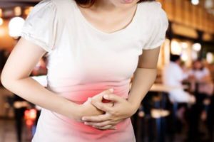 Woman holding stomach in pain