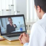 Person videochatting with doctor holding medication
